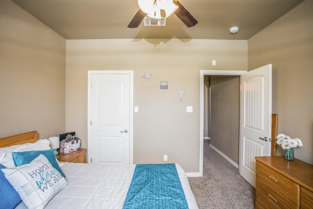 carpeted bedroom with visible vents, baseboards, and ceiling fan