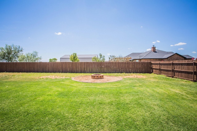 view of yard featuring a fire pit and a fenced backyard