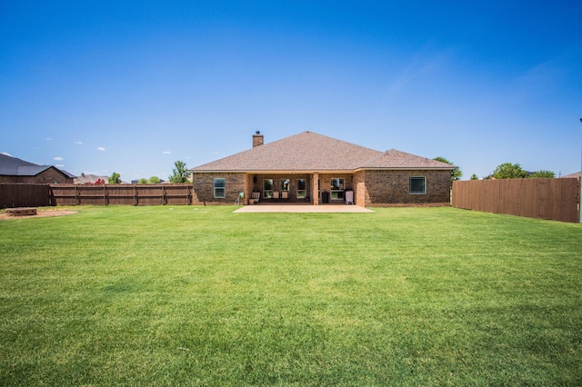 back of property featuring a patio, a yard, and a fenced backyard