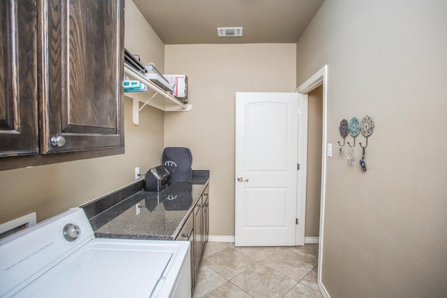 clothes washing area with light tile patterned floors, visible vents, washer / dryer, baseboards, and cabinet space