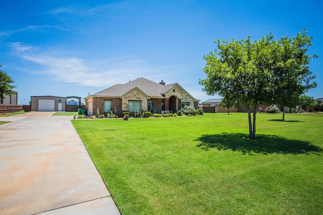 view of front of house featuring stone siding, concrete driveway, a front yard, and fence