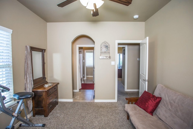 interior space with ceiling fan, baseboards, and carpet