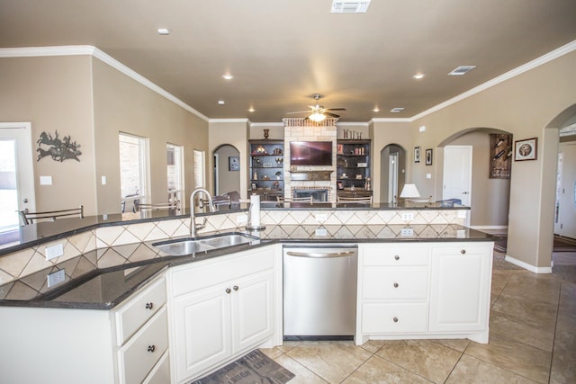 kitchen with light tile patterned floors, a ceiling fan, arched walkways, dishwasher, and a sink