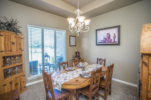 carpeted dining room featuring baseboards and a chandelier
