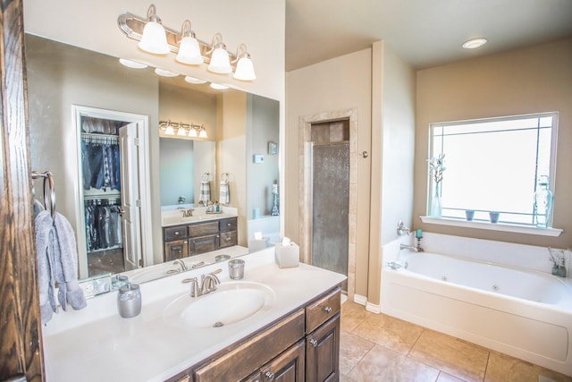 full bathroom featuring vanity, a spacious closet, tile patterned flooring, and a tub with jets