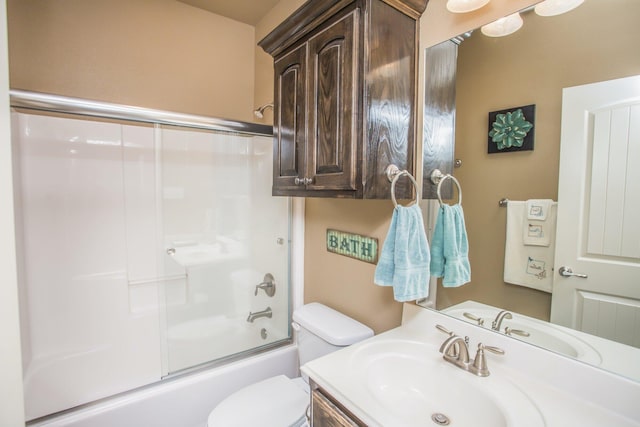 full bath featuring toilet, shower / bath combination with glass door, and vanity