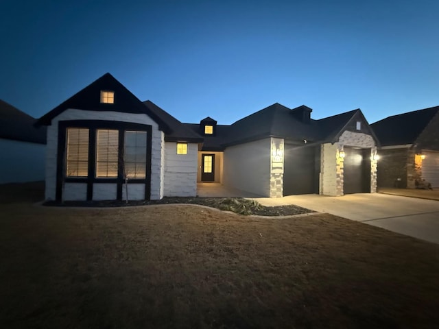 view of front of house with a garage, driveway, and stone siding