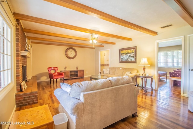 3404 59th St, Lubbock, TX 79413 - living area with baseboards, wood finished floors, beamed ceiling, a fireplace, and a ceiling fan