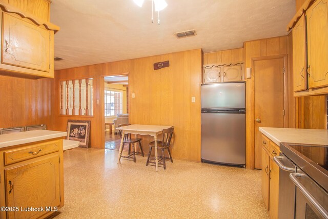 3404 59th St, Lubbock, TX 79413 - kitchen featuring stainless steel appliances, light countertops, and wooden walls