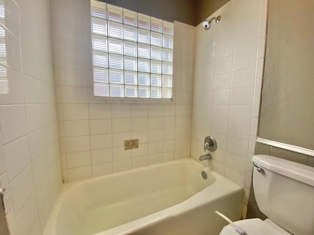 bathroom featuring tiled shower / bath and toilet