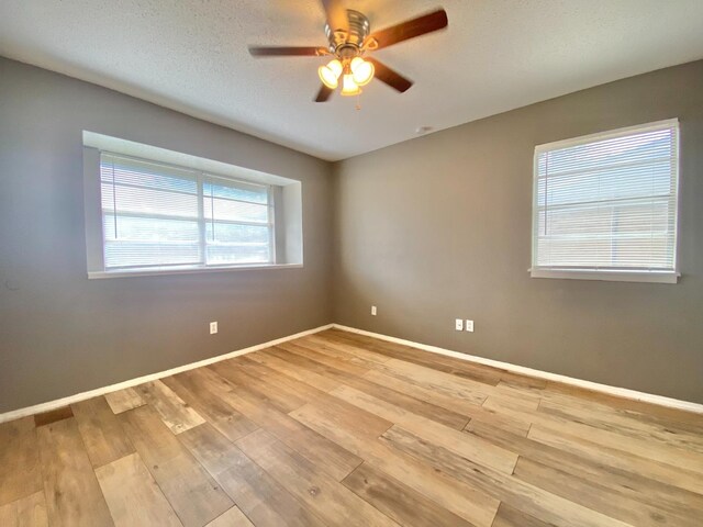 spare room with a textured ceiling, light hardwood / wood-style floors, and ceiling fan