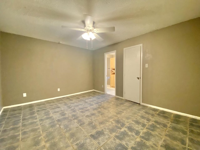 empty room with a textured ceiling and ceiling fan