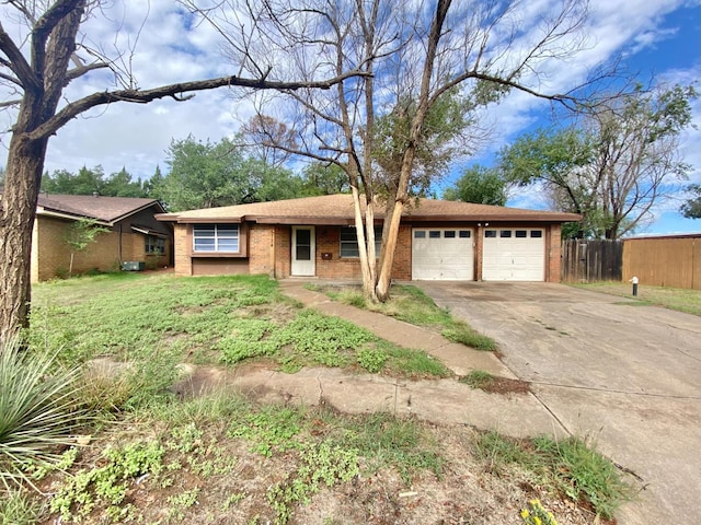 single story home featuring a front lawn and a garage