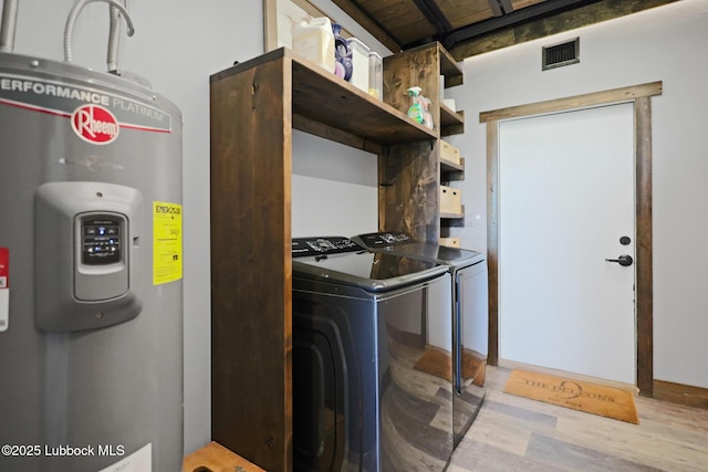 743 Co Rd, M, Tahoka, TX 79373 - washroom with electric water heater, washing machine and clothes dryer, and wood finished floors