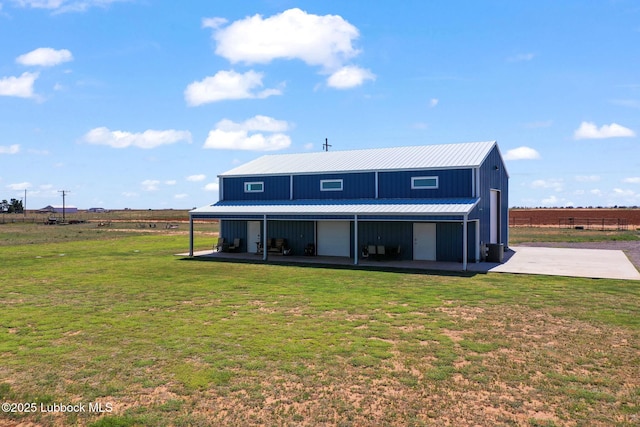 743 Co Rd, M, Tahoka, TX 79373 - back of property with a yard, metal roof, central air condition unit, and board and batten siding