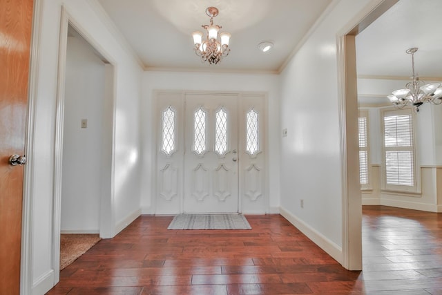 entryway with dark hardwood / wood-style flooring, crown molding, and a chandelier