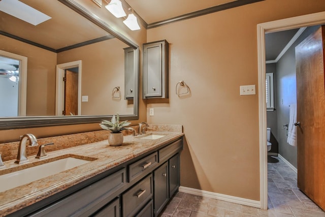 bathroom featuring ornamental molding, vanity, ceiling fan, and toilet