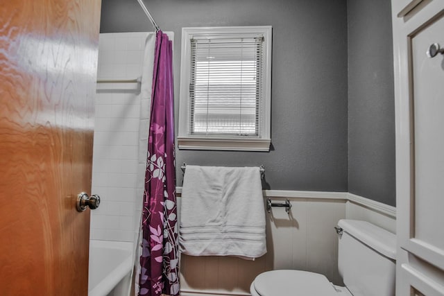 bathroom with shower / bath combination with curtain and toilet