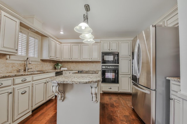 kitchen with hanging light fixtures, black appliances, a center island, and light stone countertops