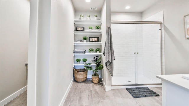 bathroom with an enclosed shower and hardwood / wood-style floors