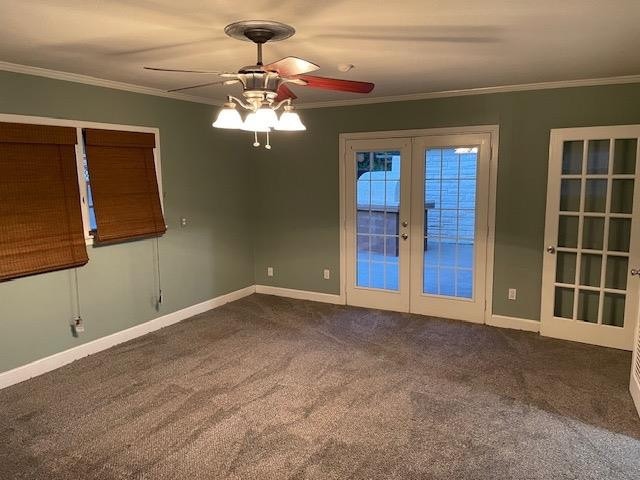 unfurnished room featuring dark carpet, ornamental molding, french doors, and ceiling fan