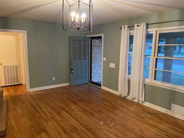 entrance foyer featuring wood-type flooring and a chandelier