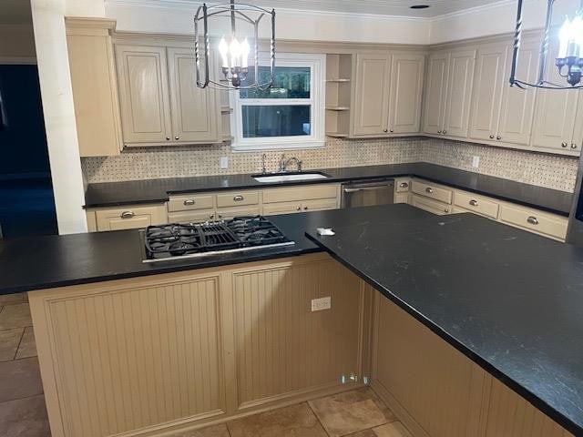 kitchen featuring pendant lighting, sink, backsplash, a notable chandelier, and black gas stovetop