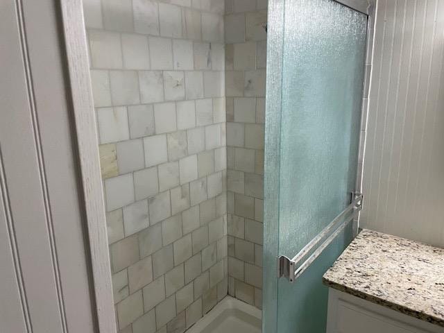 bathroom with a shower with door and vanity