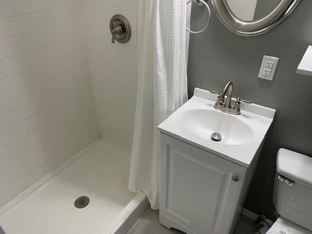 bathroom with toilet, vanity, and a shower with shower curtain