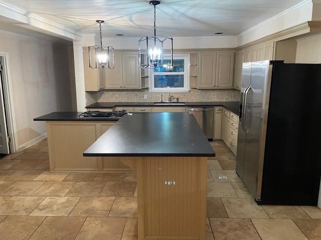 kitchen featuring sink, a center island, hanging light fixtures, stainless steel appliances, and backsplash