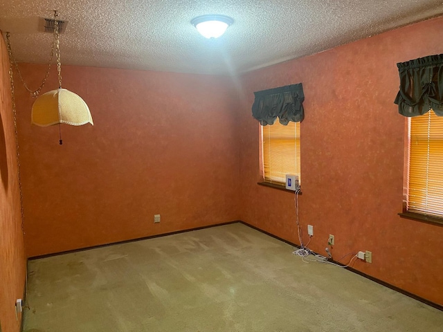 carpeted spare room with a textured ceiling