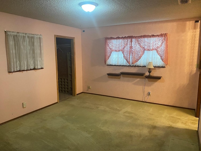 spare room featuring carpet floors and a textured ceiling