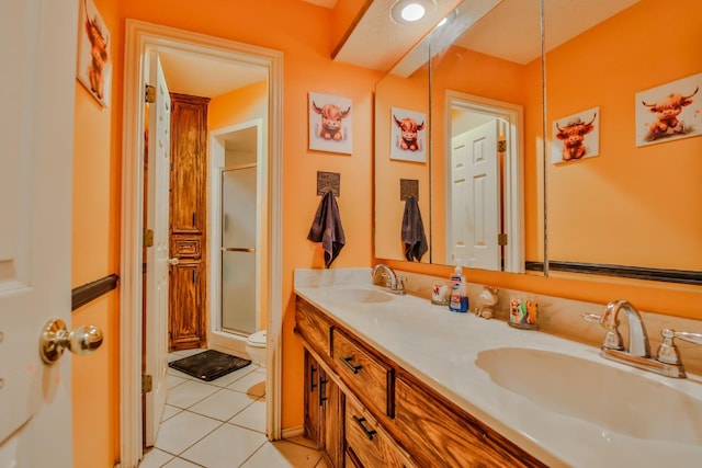 bathroom with vanity, toilet, a shower with shower door, and tile patterned flooring