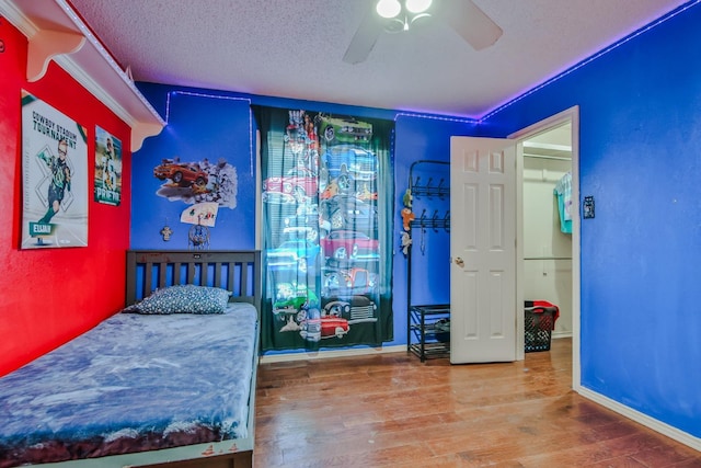 bedroom with hardwood / wood-style floors, a textured ceiling, and ceiling fan