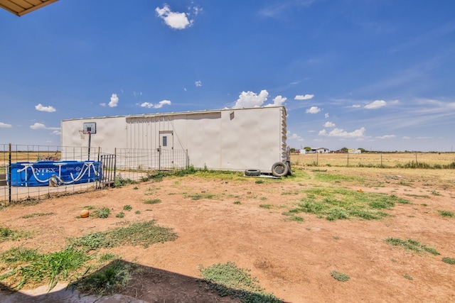 view of yard featuring an outdoor structure and a rural view