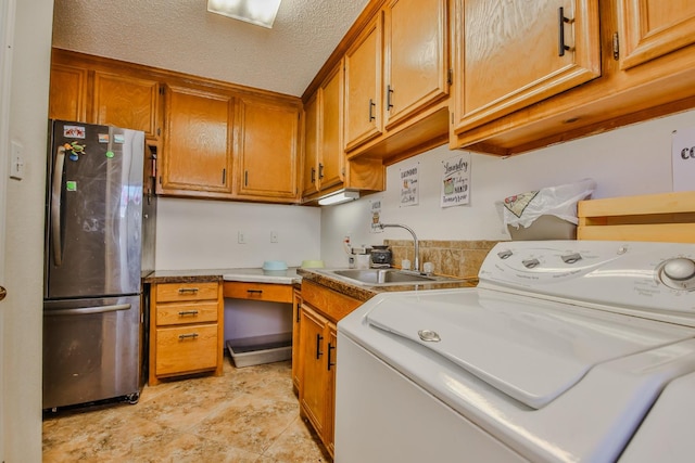 laundry area with sink, washer / dryer, and a textured ceiling