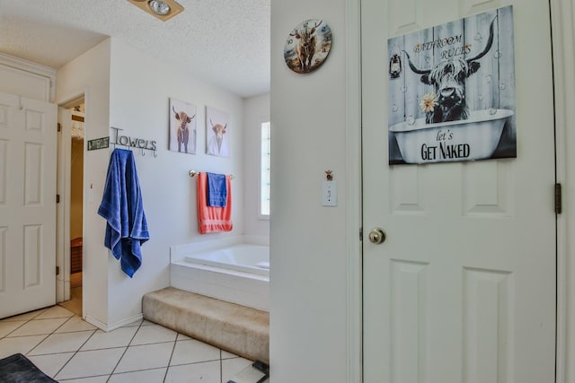 bathroom with a bathtub, tile patterned floors, and a textured ceiling