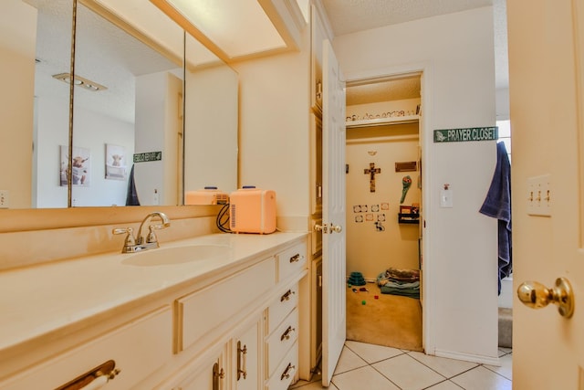 bathroom with tile patterned floors, a textured ceiling, and vanity