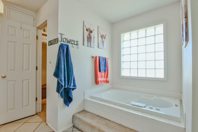 bathroom featuring tile patterned flooring, tiled bath, and a textured ceiling