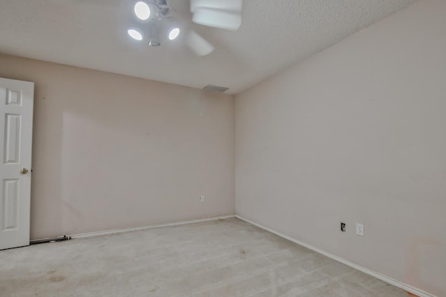 carpeted spare room with a textured ceiling and ceiling fan