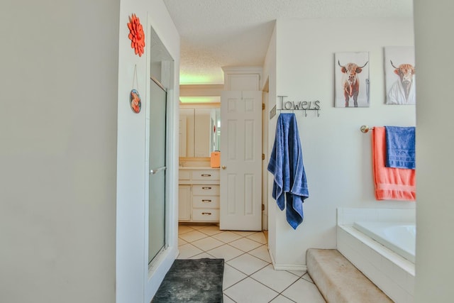 bathroom with tile patterned floors, shower with separate bathtub, and a textured ceiling