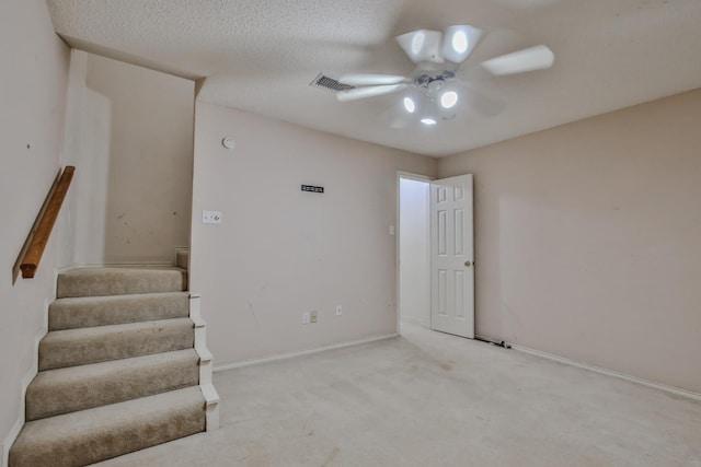 carpeted spare room with a textured ceiling and ceiling fan