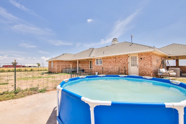 view of swimming pool with central AC unit