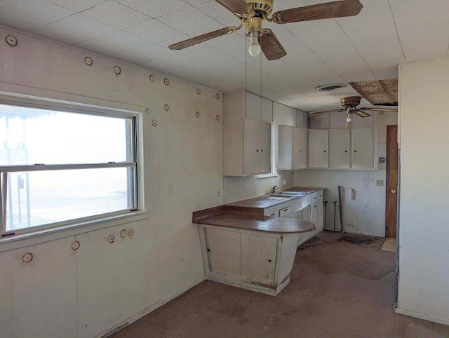 kitchen featuring white cabinetry, sink, ceiling fan, and kitchen peninsula