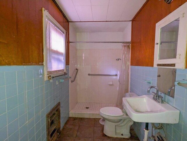 bathroom with sink, toilet, a shower with shower curtain, and tile walls