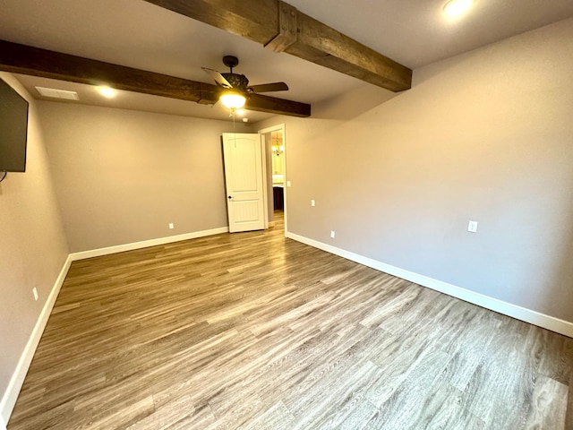 empty room featuring beamed ceiling, ceiling fan, and light hardwood / wood-style floors