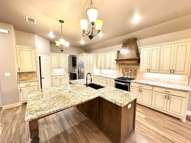 kitchen featuring sink, tasteful backsplash, decorative light fixtures, appliances with stainless steel finishes, and custom range hood