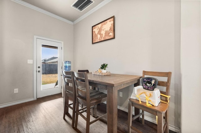 dining area with crown molding and dark wood-type flooring