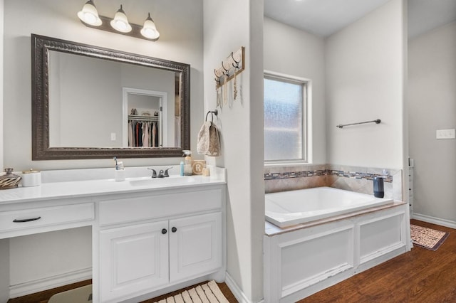 bathroom featuring vanity, hardwood / wood-style flooring, and a bathing tub