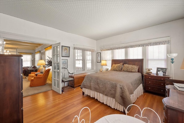 bedroom with multiple windows and wood finished floors